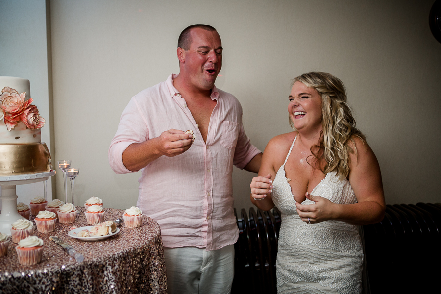 Laughing while eating cake at this Daytona Beach Wedding by Destination Wedding Photographer, Amanda May Photos.