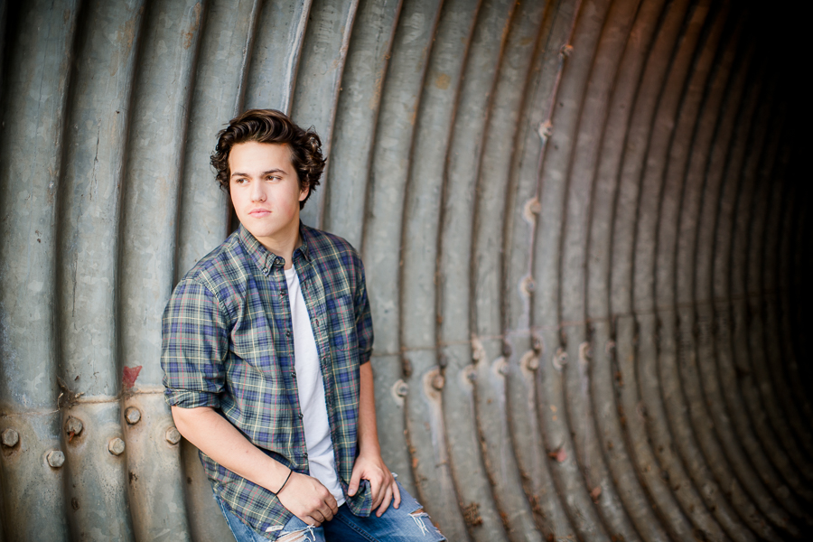 Leaning against metal tunnel at this Maryville, TN Senior session by Knoxville Wedding Photographer, Amanda May Photos.