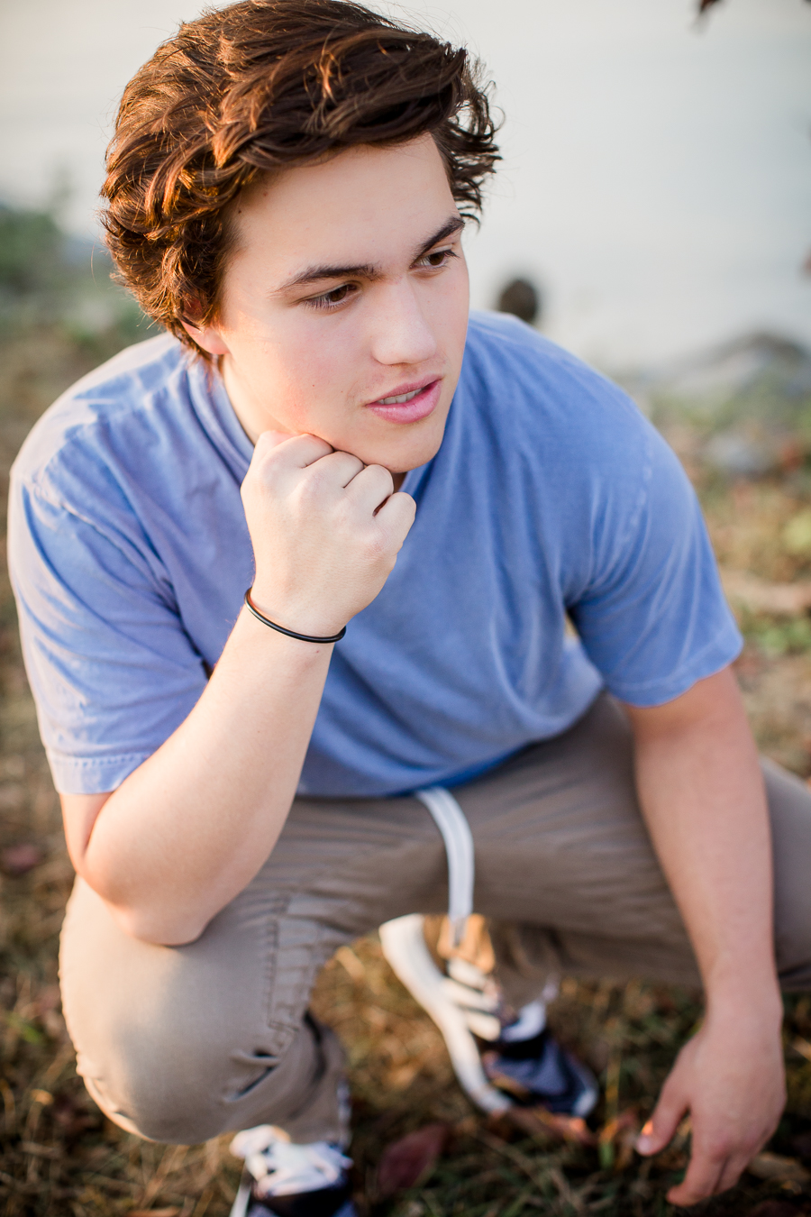 Chin on his hand squatting at this Maryville, TN Senior session by Knoxville Wedding Photographer, Amanda May Photos.