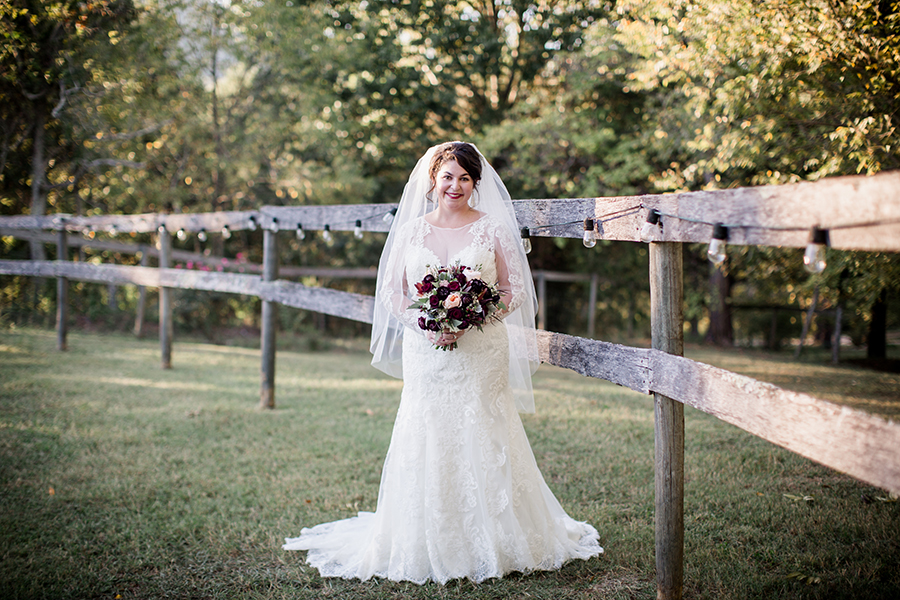 Standing along fence row at this bridal session at The Barn at High Point Farms by Knoxville Wedding Photographer, Amanda May Photos.