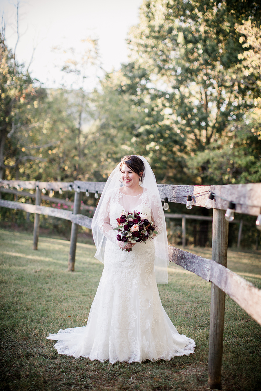 Standing on fence row looking to the side at this bridal session at The Barn at High Point Farms by Knoxville Wedding Photographer, Amanda May Photos.