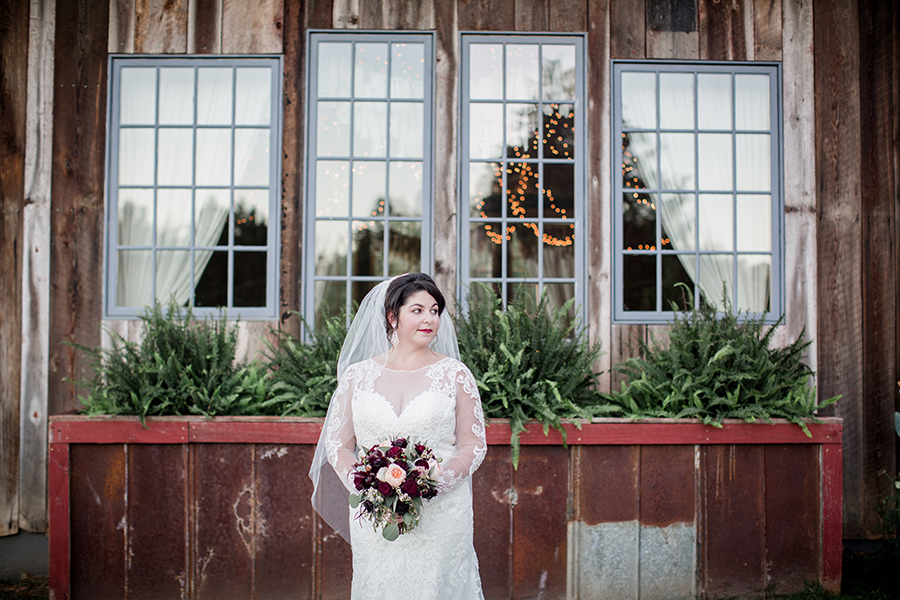 Standing in front of windows looking to the side at this bridal session at The Barn at High Point Farms by Knoxville Wedding Photographer, Amanda May Photos.