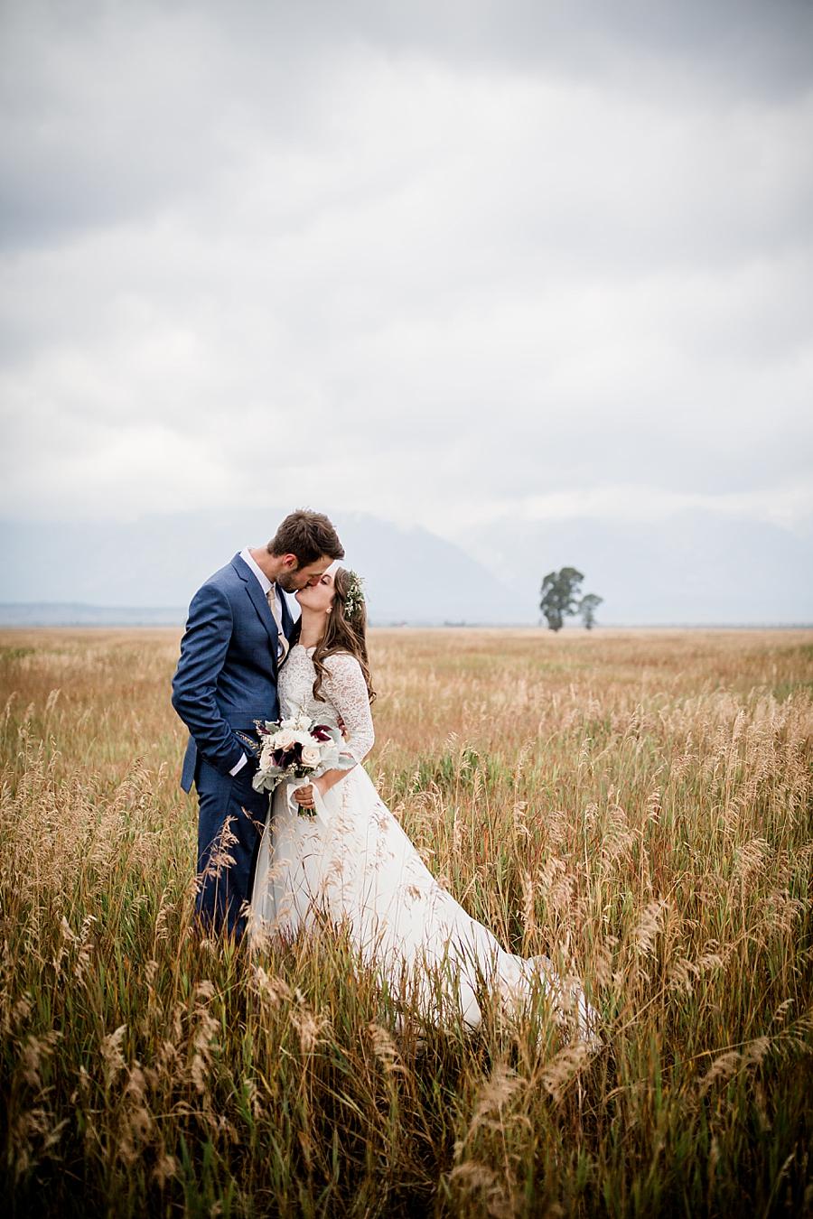 Kissing in field at this Grand Tetons Destination Wedding by Knoxville Wedding Photographer, Amanda May Photos.