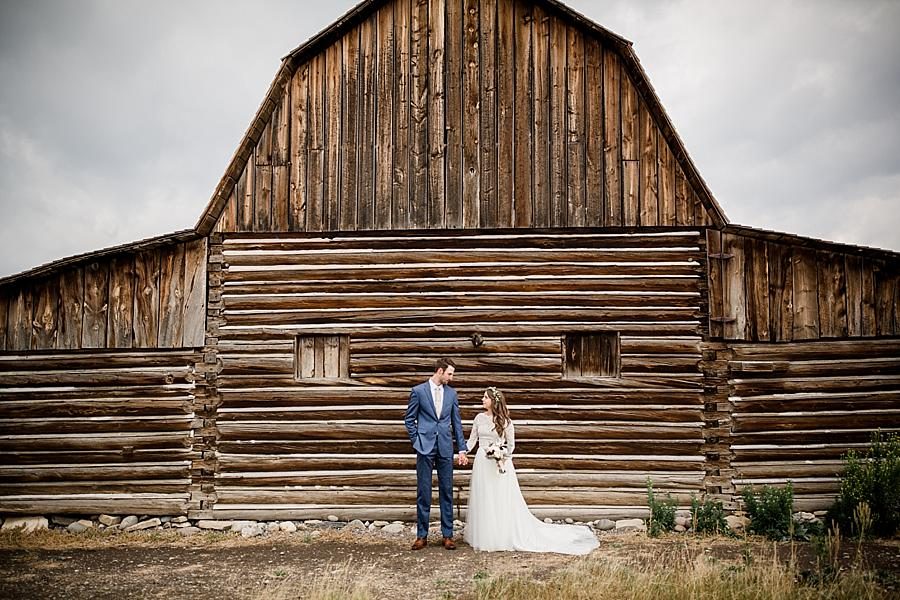 Standing infront of cabinat this Grand Tetons Destination Wedding by Knoxville Wedding Photographer, Amanda May Photos.