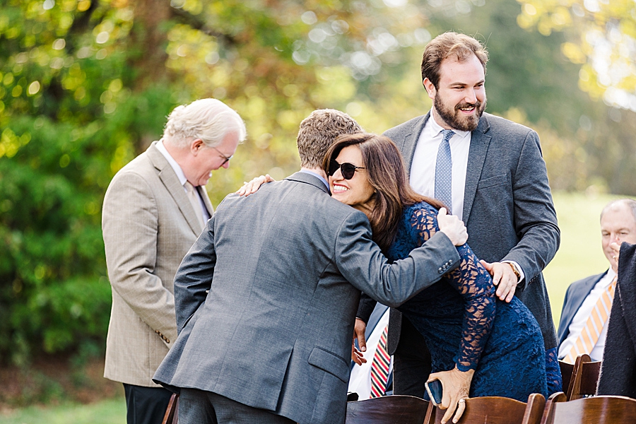 Guests hugging at ceremony at this fall castleton farms wedding