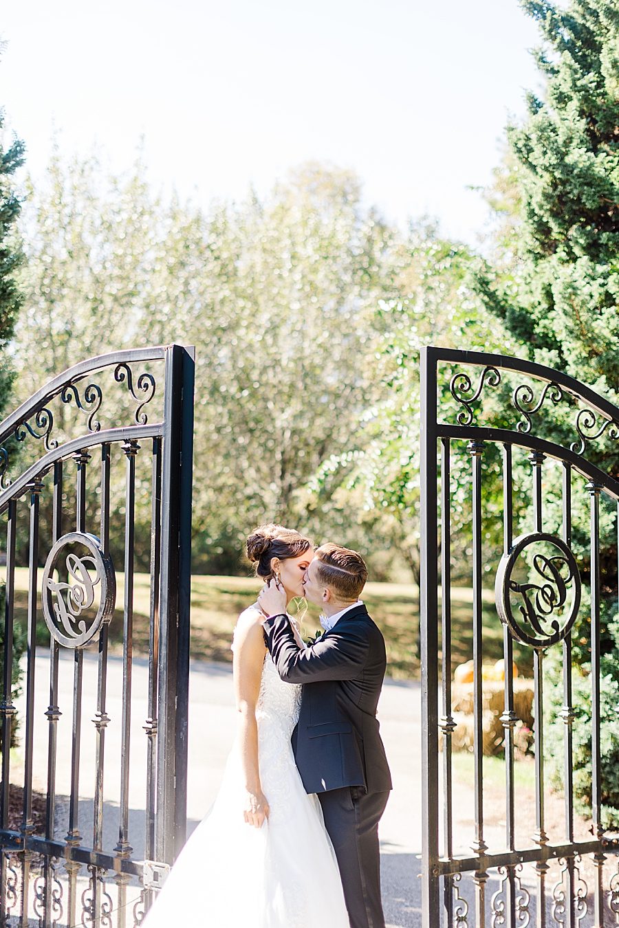 kissing by the black gate at this fall wedding at castleton farms