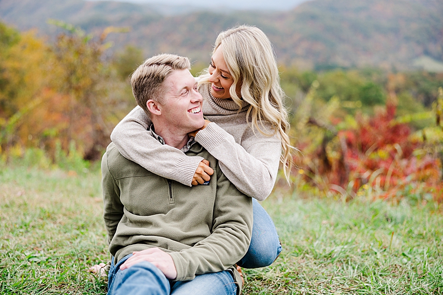 couple sitting in the grass at this foothills parkway engagement