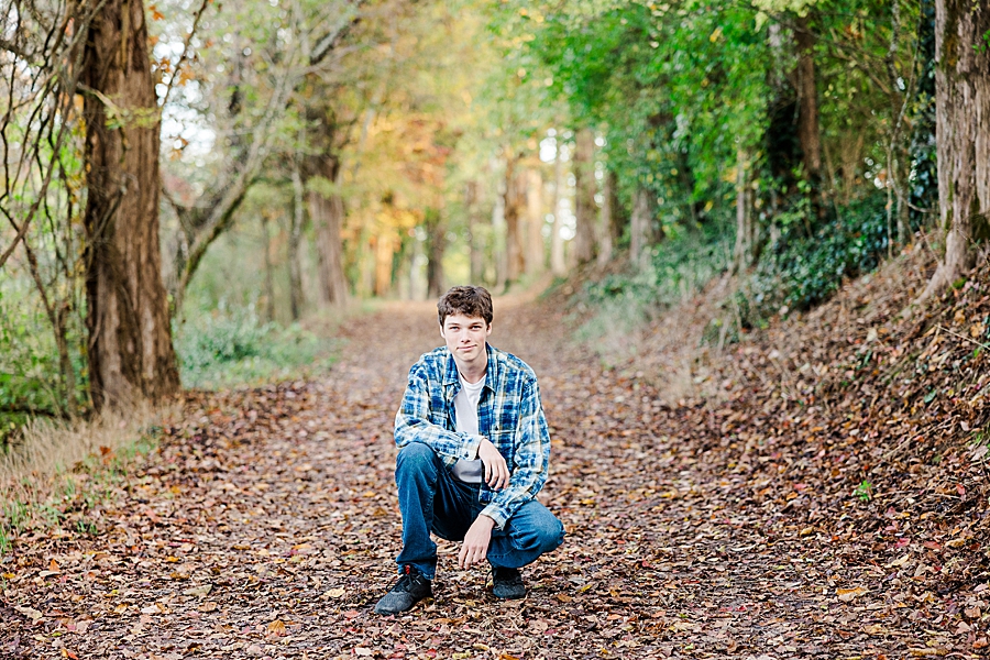 boy squatting in leaves