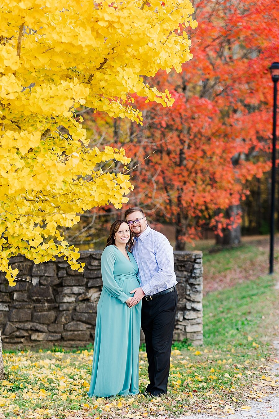 couple standing under yellow tree