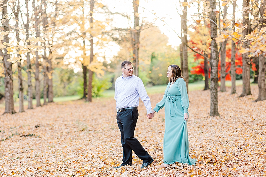 couple holding hands at their golden knoxville botanical maternity session