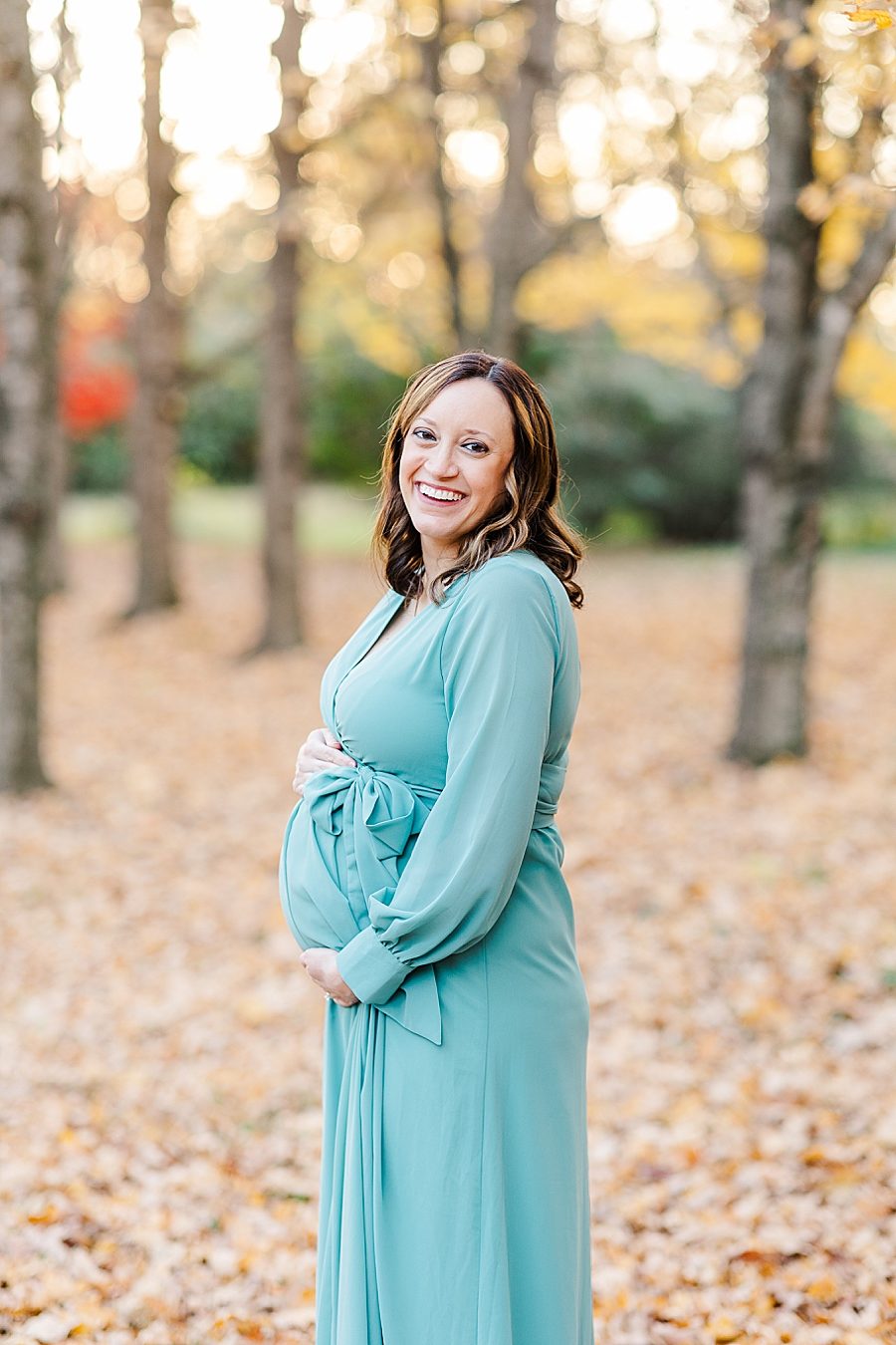 pregnant woman smiling at her golden knoxville botanical maternity session