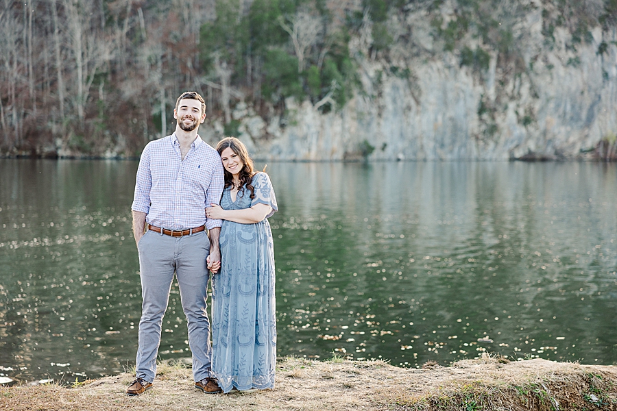 couple standing by lake at golden melton hill maternity session