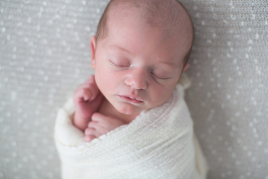 Cuddled in a white swaddle at this American Flag newborn session by Knoxville Wedding Photographer, Amanda May Photos.