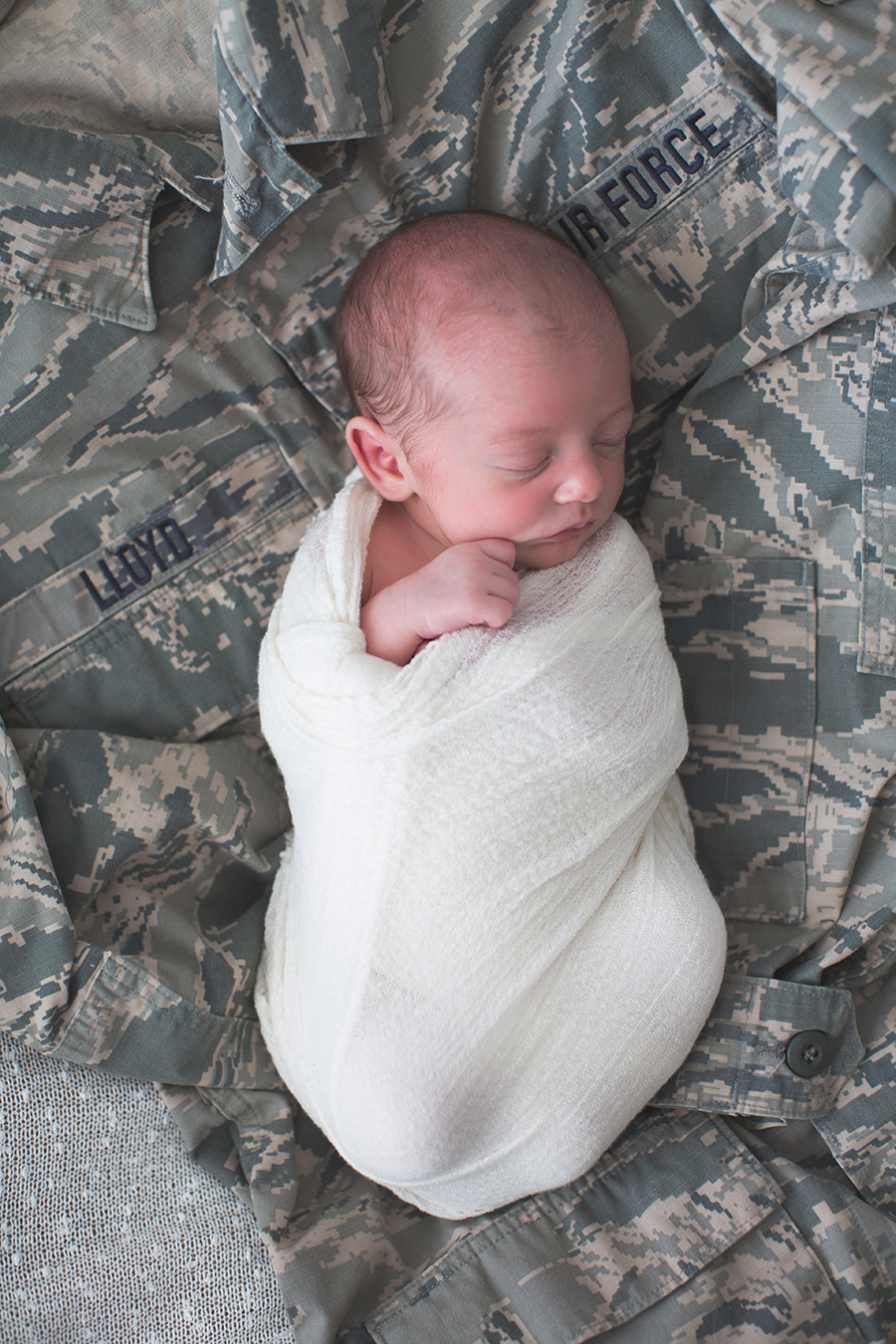 Laying swaddled on her dad's airforce jacket at this American Flag newborn session by Knoxville Wedding Photographer, Amanda May Photos.
