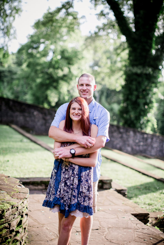 Arms wrapped around her at this Knoxville Botanical Gardens engagement session by Knoxville Wedding Photographer, Amanda May Photos.