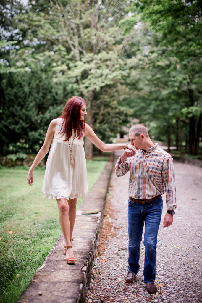 He kisses her hand at this Knoxville Botanical Gardens engagement session by Knoxville Wedding Photographer, Amanda May Photos.
