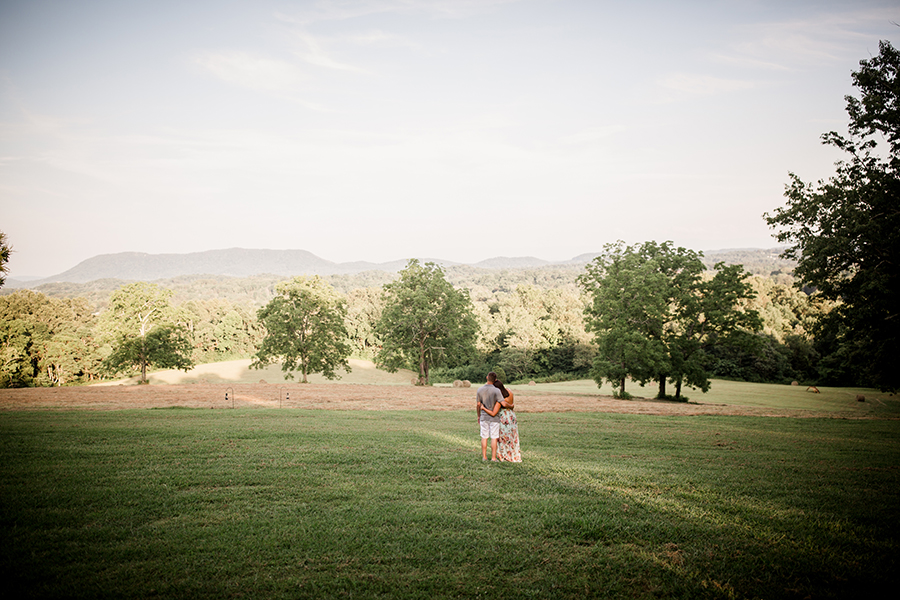 Holding each other looking at view at this Estate of Grace engagement session by Knoxville Wedding Photographer, Amanda May Photos.