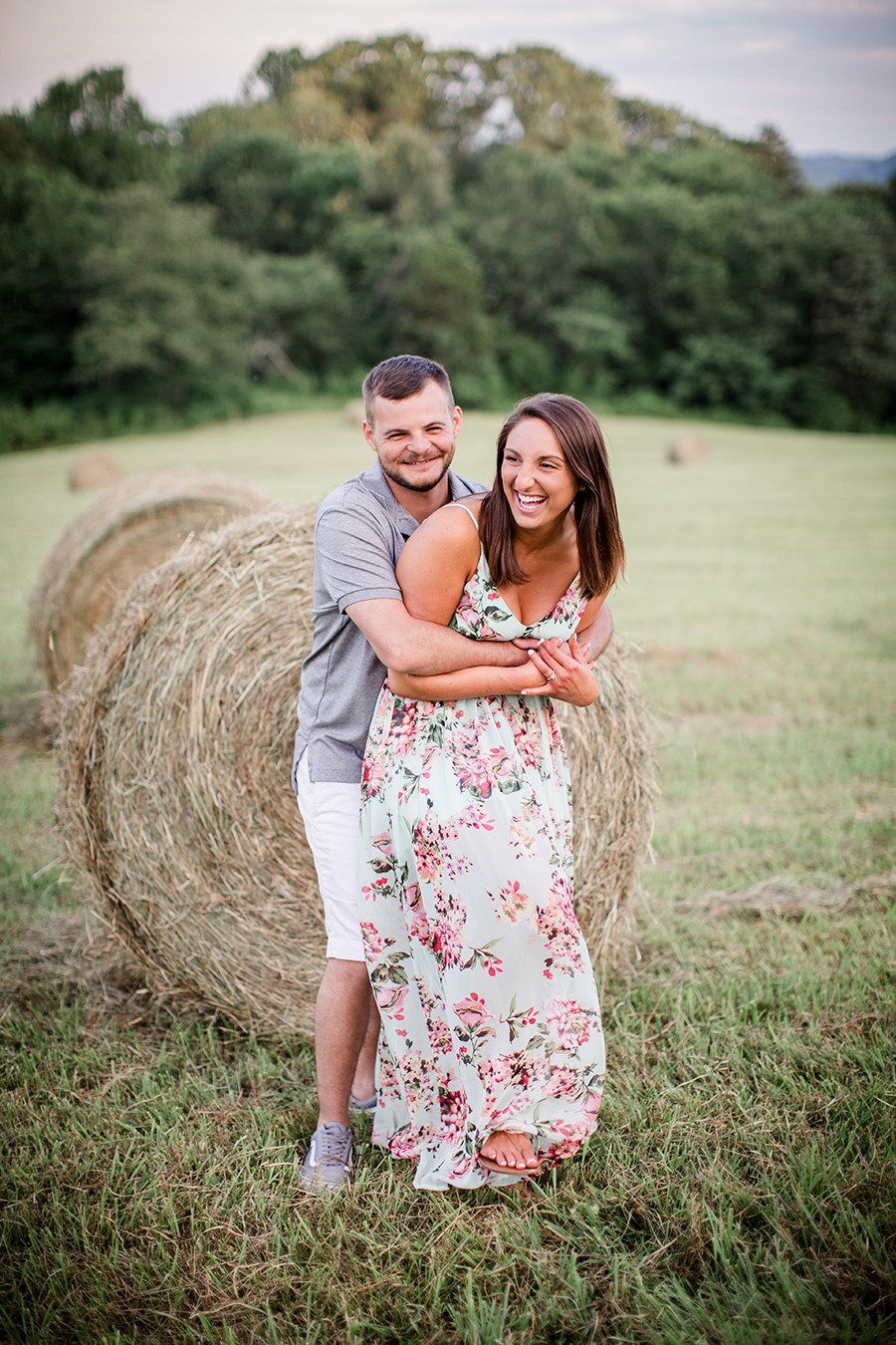 Laughing in front of hay barrels at this Estate of Grace engagement session by Knoxville Wedding Photographer, Amanda May Photos.