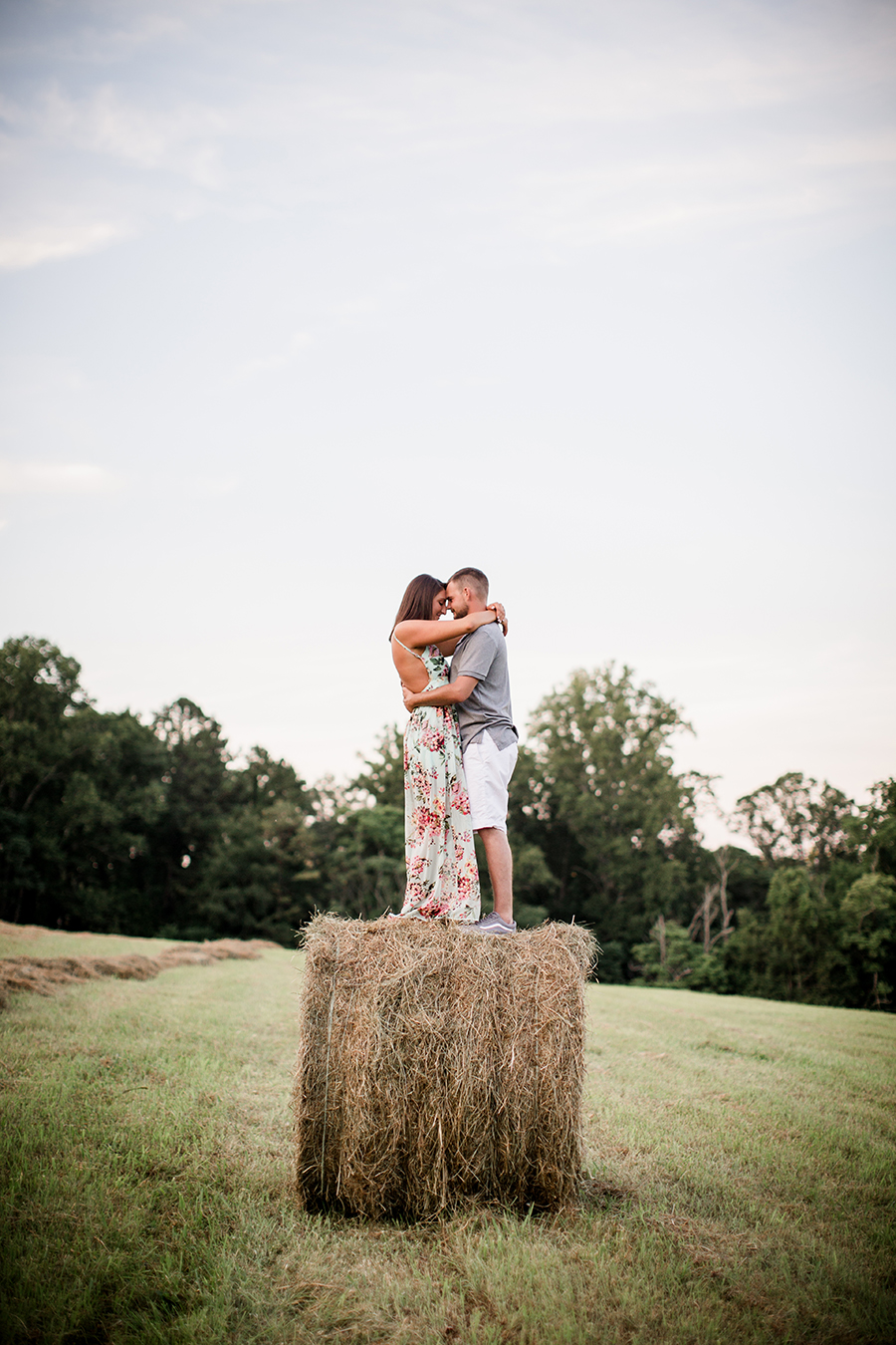 Holding each other on top of hay barrel at this Estate of Grace engagement session by Knoxville Wedding Photographer, Amanda May Photos.