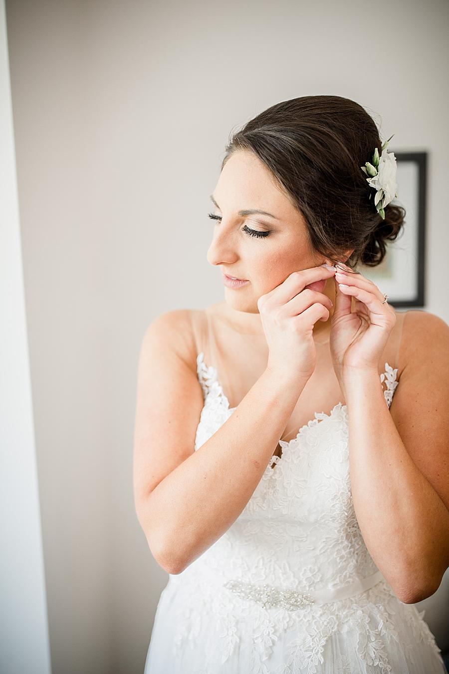 Putting on earrings at this Estate of Grace Wedding by Knoxville Wedding Photographer, Amanda May Photos.