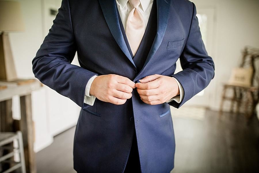 Groom buttoning jacket at this Estate of Grace Wedding by Knoxville Wedding Photographer, Amanda May Photos.