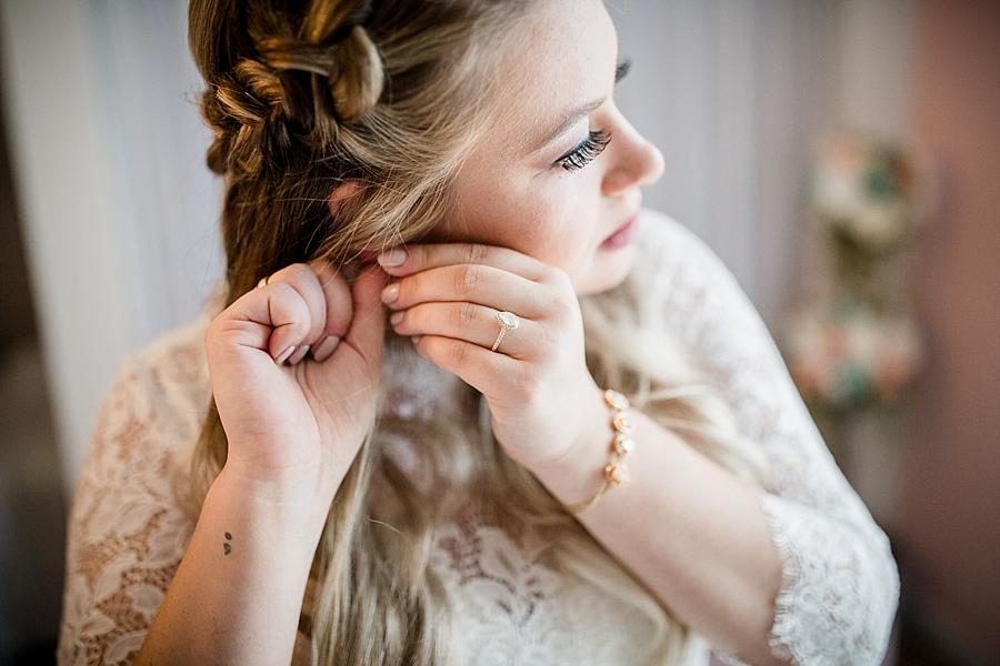 Putting on earrings at this Cheval Manor Wedding by Knoxville Wedding Photographer, Amanda May Photos.