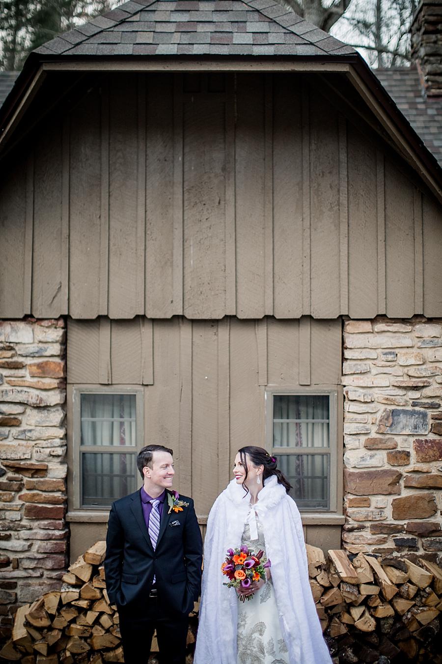 Standing in front of cut firewood at this Cumberland Mountain State Park wedding by Knoxville Wedding Photographer, Amanda May Photos.