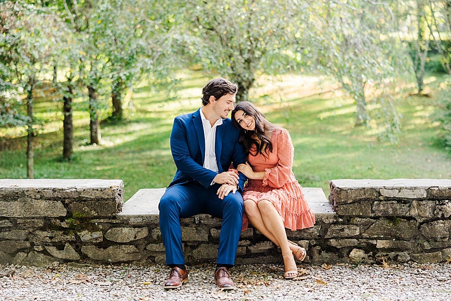 sitting on a stone wall at knoxville botanical garden engagement
