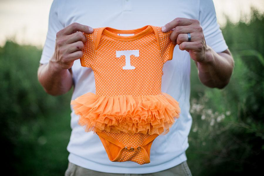 Dad holding the tennessee onesie at this Sterchi Hills maternity session by Knoxville Wedding Photographer, Amanda May Photos.