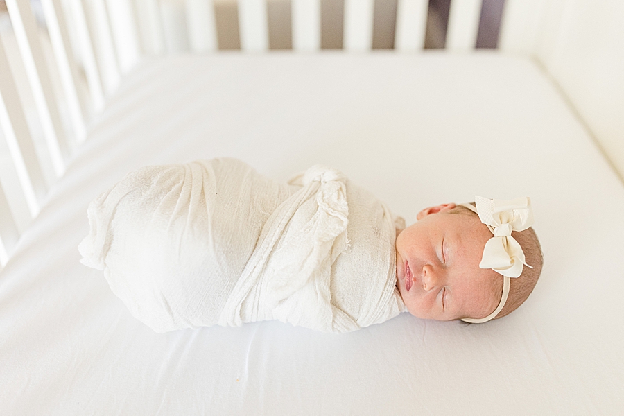 swaddled baby in crib at this lifestyle newborn session