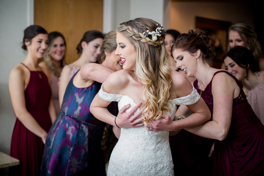 Mom and sister zipping up the bride's dress during this getting ready picture at this winter wedding at Knoxville Wedding Venue, Jackson Terminal, by Knoxville Wedding Photographer, Amanda May Photos.