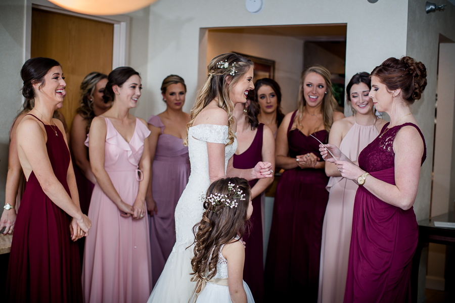 Maid of honor and sister reading the groom's letter to the bride during this getting ready picture at this winter wedding at Knoxville Wedding Venue, Jackson Terminal, by Knoxville Wedding Photographer, Amanda May Photos.
