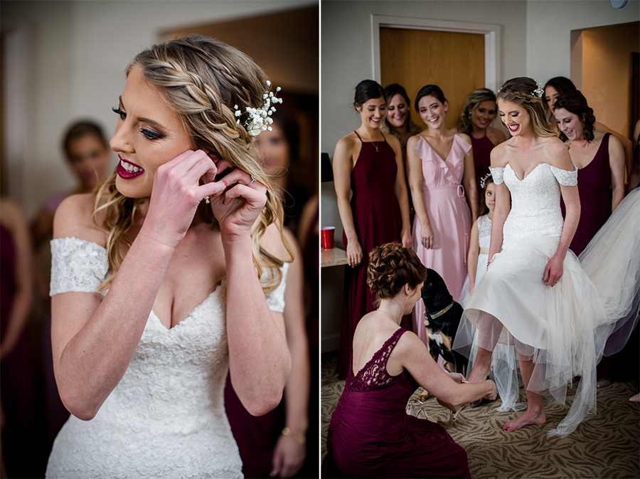 Bride putting her earrings in and sister putting the bride's shoes on during this getting ready picture at this winter wedding at Knoxville Wedding Venue, Jackson Terminal, by Knoxville Wedding Photographer, Amanda May Photos.