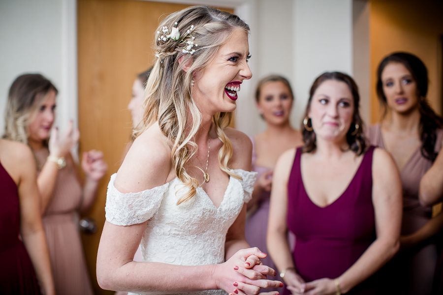 Bride laughing after she gets her dress on during this getting ready picture at this winter wedding at Knoxville Wedding Venue, Jackson Terminal, by Knoxville Wedding Photographer, Amanda May Photos.