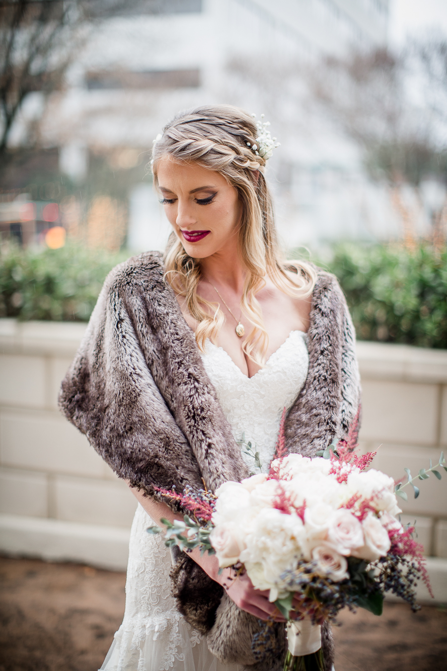 Bride looking down over her shoulder during the bride and bridesmaids pictures at this winter wedding at Knoxville Wedding Venue, Jackson Terminal, by Knoxville Wedding Photographer, Amanda May Photos.