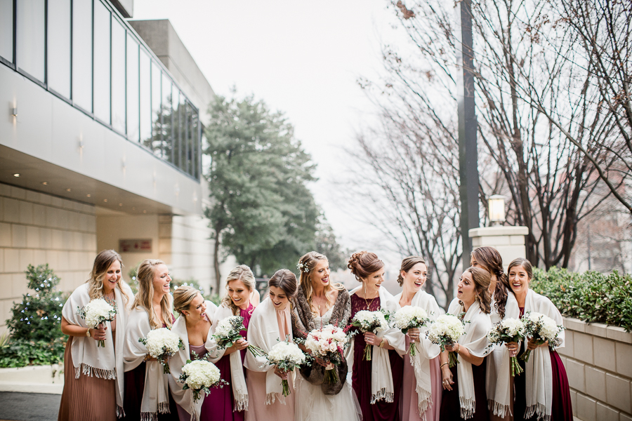 Hips up of the girls laughing together during the bride and bridesmaids pictures at this winter wedding at Knoxville Wedding Venue, Jackson Terminal, by Knoxville Wedding Photographer, Amanda May Photos.