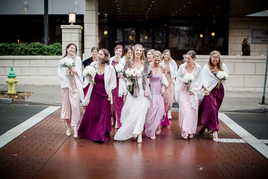 Crossing the street during the bride and bridesmaids pictures at this winter wedding at Knoxville Wedding Venue, Jackson Terminal, by Knoxville Wedding Photographer, Amanda May Photos.