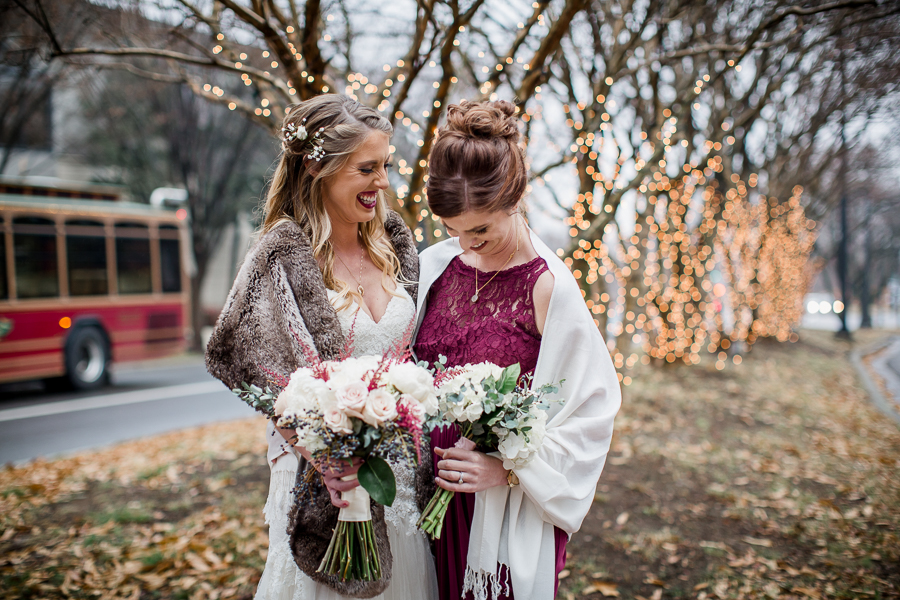 Sisters laughing together during the bride and bridesmaids pictures at this winter wedding at Knoxville Wedding Venue, Jackson Terminal, by Knoxville Wedding Photographer, Amanda May Photos.