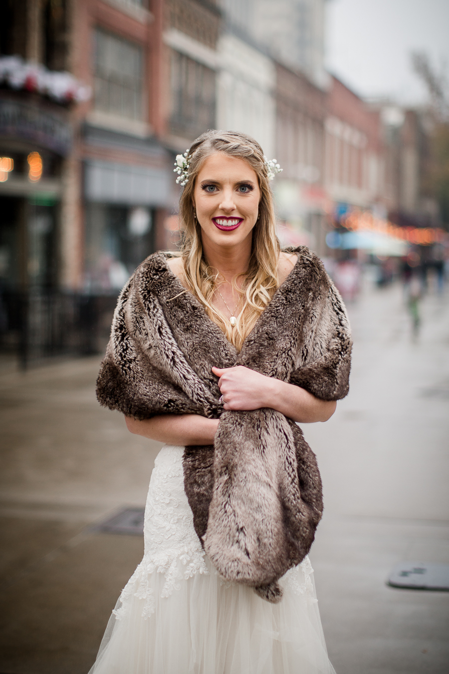 Holding her fur around her shoulders during the bride and bridesmaids pictures at this winter wedding at Knoxville Wedding Venue, Jackson Terminal, by Knoxville Wedding Photographer, Amanda May Photos.
