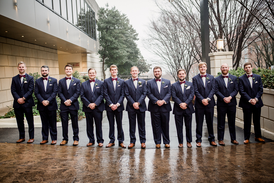 Standing shoulder to shoulder looking at the camera during the groom and groomsmen pictures at this winter wedding at Knoxville Wedding Venue, Jackson Terminal, by Knoxville Wedding Photographer, Amanda May Photos.