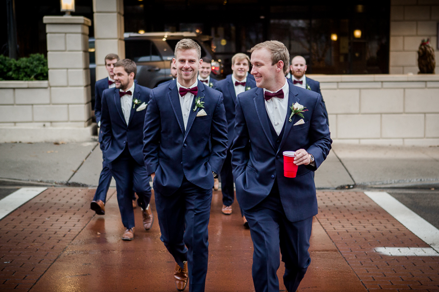 Crossing the street during the groom and groomsmen pictures at this winter wedding at Knoxville Wedding Venue, Jackson Terminal, by Knoxville Wedding Photographer, Amanda May Photos.