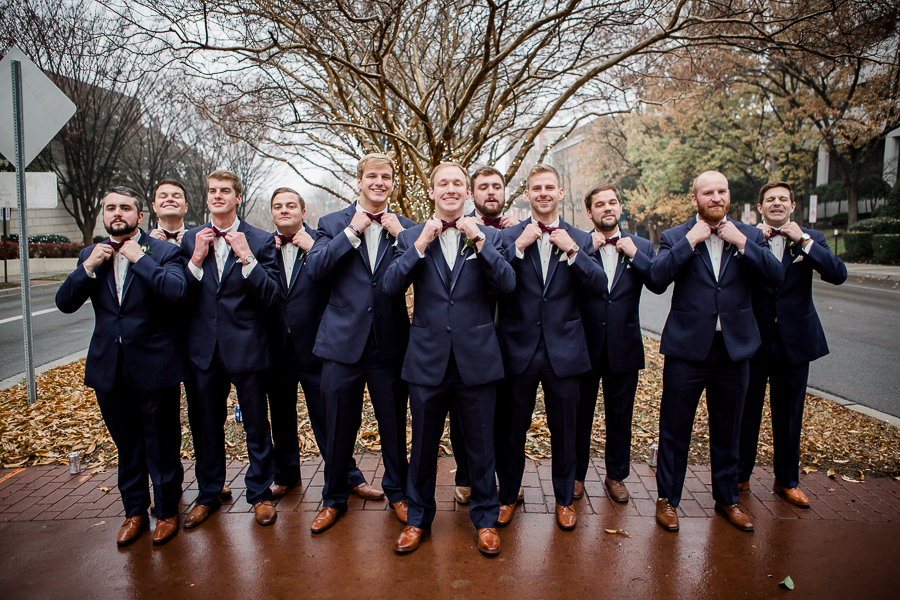 Everyone straightening their bowties during the groom and groomsmen pictures at this winter wedding at Knoxville Wedding Venue, Jackson Terminal, by Knoxville Wedding Photographer, Amanda May Photos.
