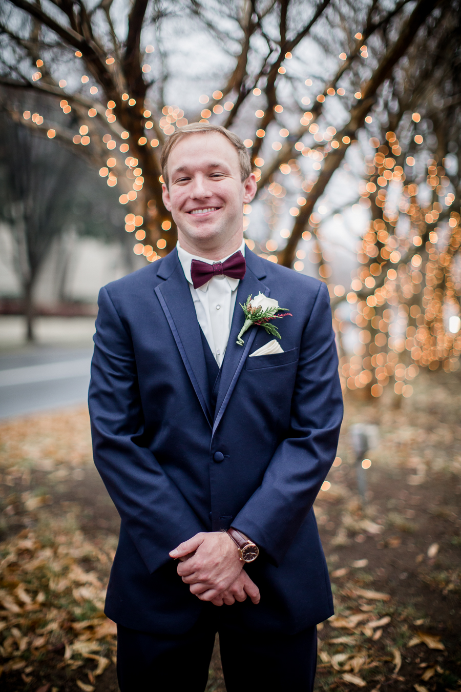 Left over right with lights in the background during the groom and groomsmen pictures at this winter wedding at Knoxville Wedding Venue, Jackson Terminal, by Knoxville Wedding Photographer, Amanda May Photos.