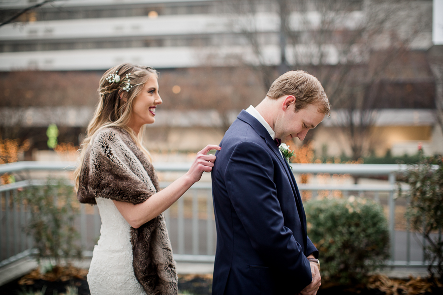 Bride tapping the groom on the shoulder during the first look pictures at this winter wedding at Knoxville Wedding Venue, Jackson Terminal, by Knoxville Wedding Photographer, Amanda May Photos.