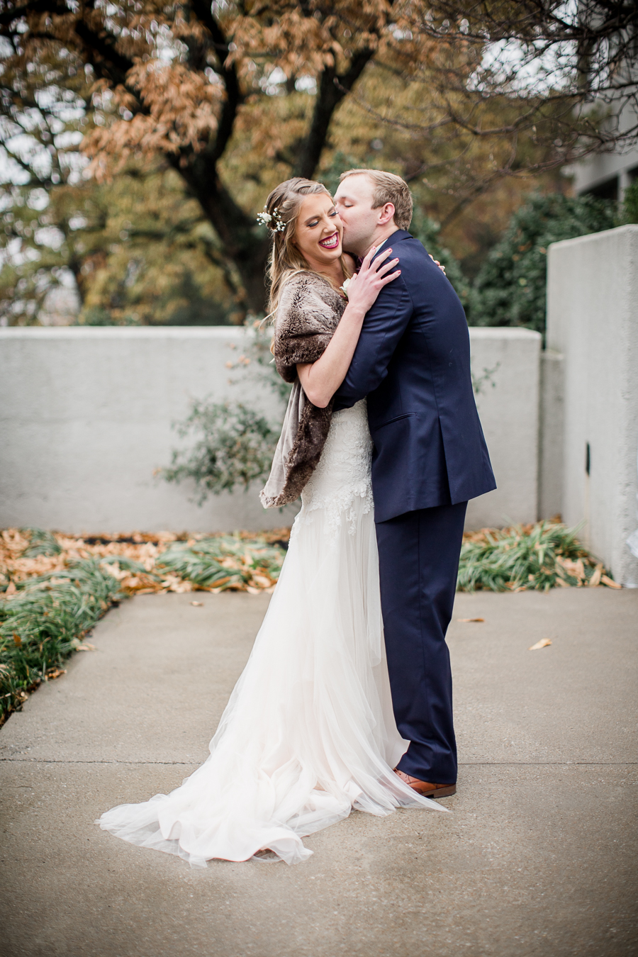 He kisses her on the cheek during the first look pictures at this winter wedding at Knoxville Wedding Venue, Jackson Terminal, by Knoxville Wedding Photographer, Amanda May Photos.