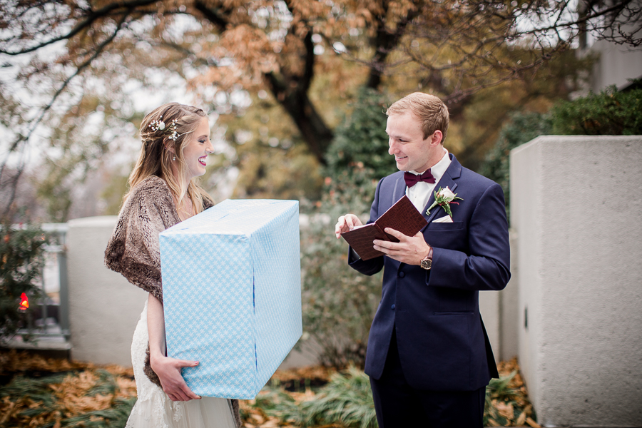 He opens his gift from her during the first look pictures at this winter wedding at Knoxville Wedding Venue, Jackson Terminal, by Knoxville Wedding Photographer, Amanda May Photos.