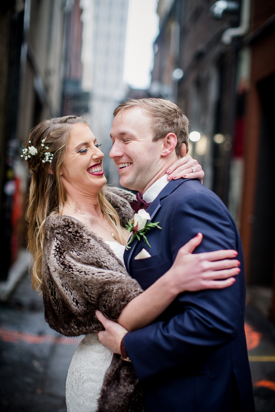 Laughing together in the art alley during the bride and groom romantic portraits at this winter wedding at Knoxville Wedding Venue, Jackson Terminal, by Knoxville Wedding Photographer, Amanda May Photos.