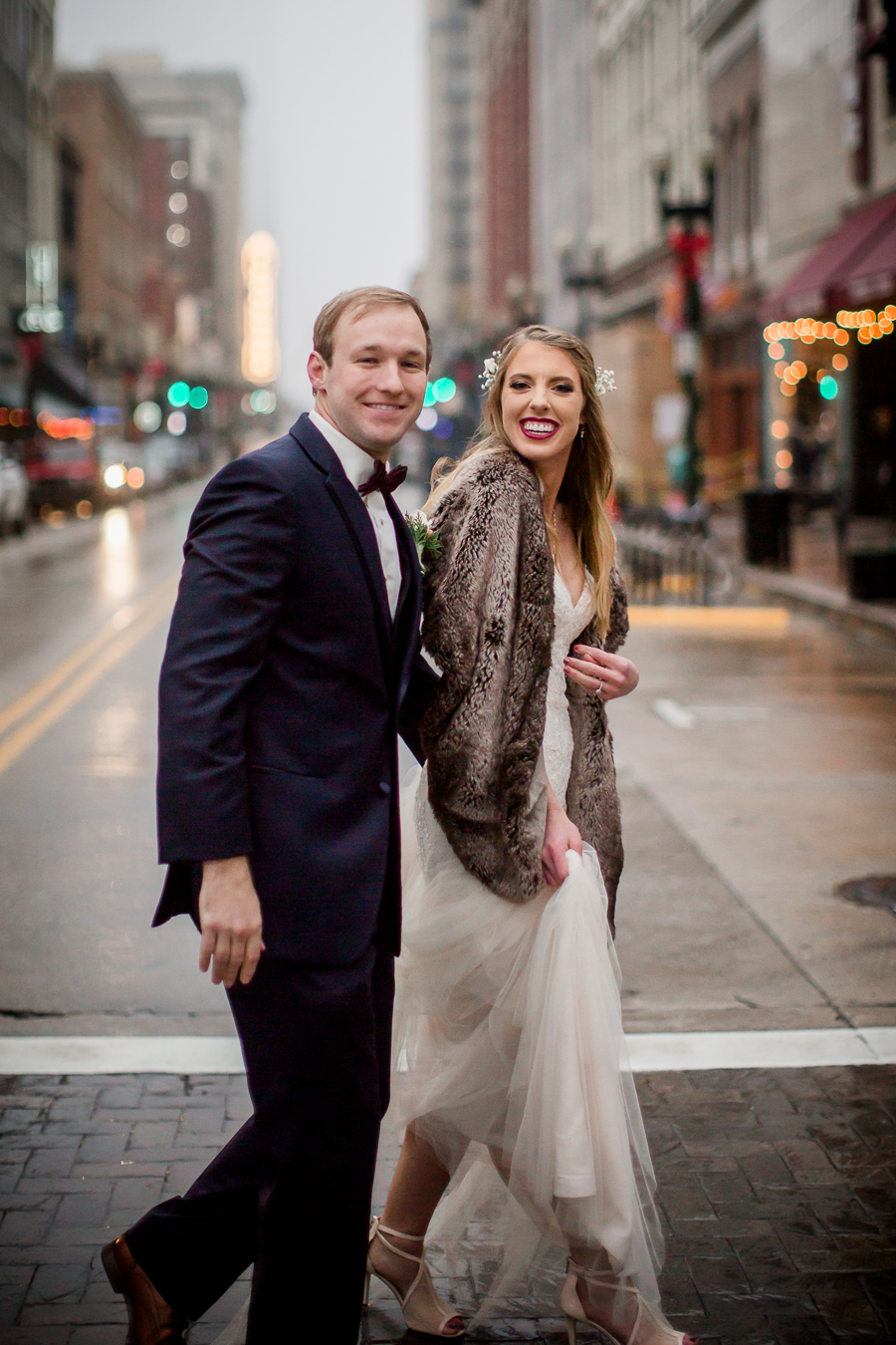 Laughing together in the middle of the street during the bride and groom romantic portraits at this winter wedding at Knoxville Wedding Venue, Jackson Terminal, by Knoxville Wedding Photographer, Amanda May Photos.