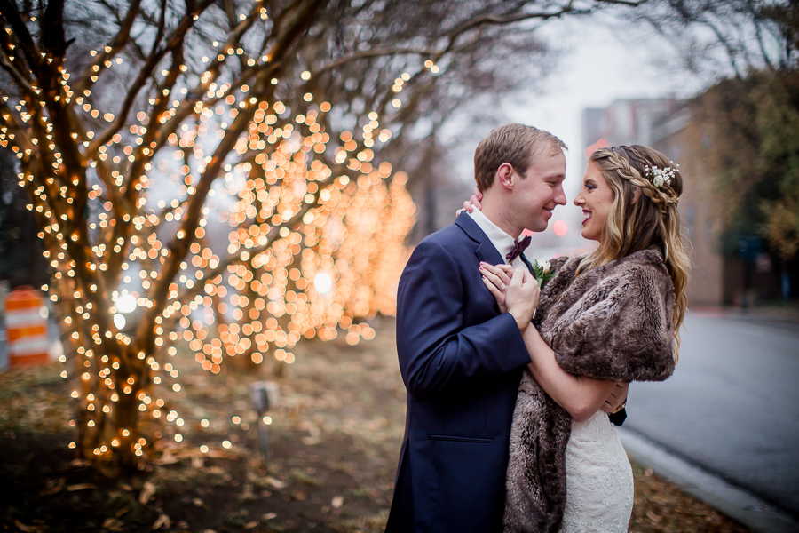 Dancing with lights in the background during the bride and groom romantic portraits at this winter wedding at Knoxville Wedding Venue, Jackson Terminal, by Knoxville Wedding Photographer, Amanda May Photos.