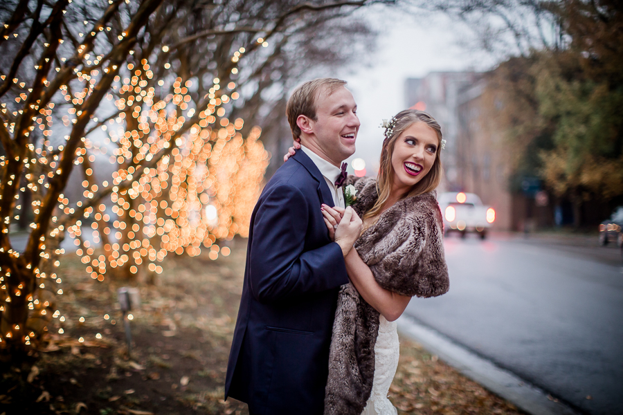 Looks back over their shoulders during the bride and groom romantic portraits at this winter wedding at Knoxville Wedding Venue, Jackson Terminal, by Knoxville Wedding Photographer, Amanda May Photos.